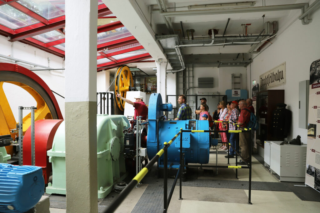 Besucher bei einer Führung im Maschinenraum der Drahtseilbahn Augustusburg